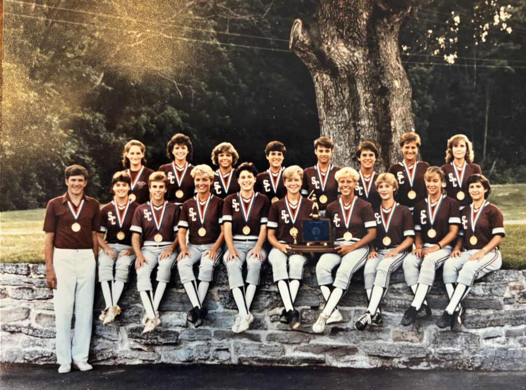 A softball team poses for a group photo