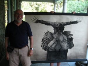 Illustrator Joseph A Smith stands in front of his work