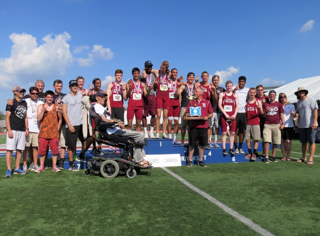A winning track team stands on top of a podium