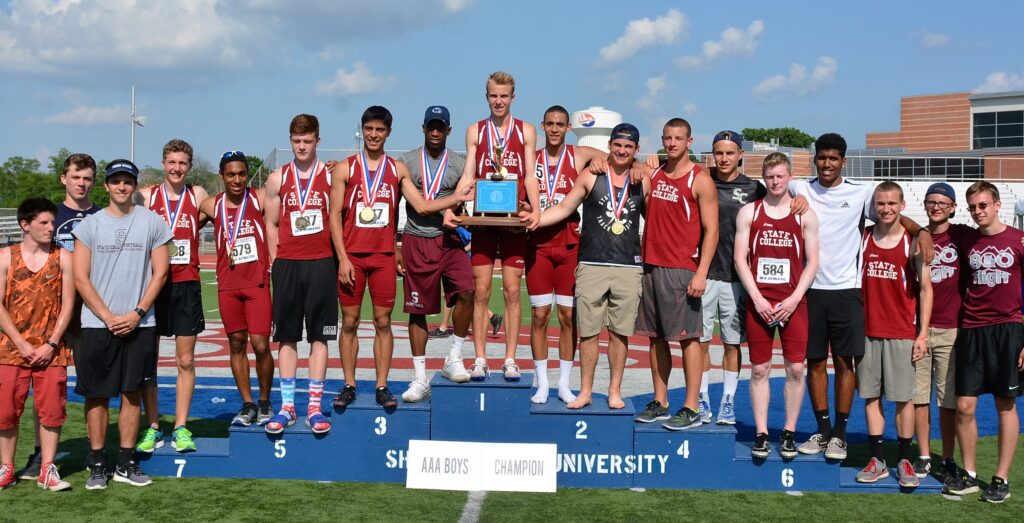 A winning track team stands at the top of a podium